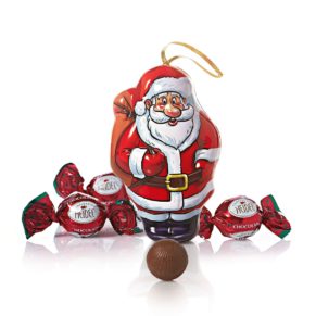 Dose in Weihnachtsmann-Form mit Aufhänger. Aus Metall gefertigt, gefüllt mit 75g Vollmilchschokoladenkugeln (Kakao 30% mind.) mit Milchcremefüllung (35%), Maße: ca. 12,5 x 6 x 8,2 cm, ca. 130 g. Zutaten: Zucker, VOLLMILCHPULVER, pflanzl. Fett (Ölpalme, Kokos), Kakaobutter, Kakaomasse, MAGERMILCHPULVER, MILCHZUCKER, Emulgator: SOJALECITHINE, natürliches Aroma. Nährwertangaben: Energie 2348 kJ (563 kcal); Fett 36g, davon gesättigte Fettsäuren 23g; Kohlenhydrate 54g, davon Zucker 54g; Eiweiß 5,8g; Salz 0,19g. Allergiehinweis: Kann Spuren von Erdnüssen, Schalenfrüchten und Gluten enthalten.<br>
