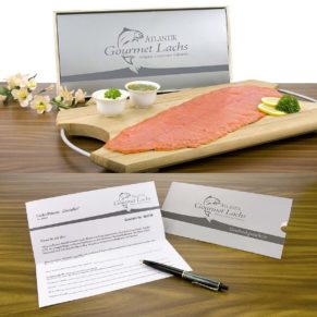 In Form eine Gutscheines wird dieser Lachs verschenkt. Der Beschenkte kann selbst bestimmen, wann und zu welchem Anlass er sein exklusives Lachspräsent frisch geliefert bekommen möchte. Rauchzarter Atlantik Gourmet Lachs 500 g, filetiert und fertig vorgeschnitten, mit feinem Sahne-Meerrettich und Senf-Dill Sauce, je 100 g, verpackt in passender Holzkiste, Maße: ca. L49 x B24 x H5,5 cm. Zutaten: Sahne-Meerrettich: Meerrettich, gerieben, Rapsöl, SAHNE 25%, Branntweinessig, Zucker, MOLKENERZEUGNIS, Verdickungsmittel, GUARKENMEHL und Xanthan, Jodsalz, Säuerungsmittel Citronensäre, Antioxidationsmittel Ascorbinsäure und Natriummetabisulfit., Senf-Dill Sauce: SENF 47% (Wasser, SENFSAATEN, Branntweinessig, Salz, Zucker, Gewürz), Zucker, Rapsöl, Branntweinessig, Dillspitzen, Gewürze, Jodsalz. , Schottischer Räucherlachs: LACHS, Salz, Eichenholzrauch.. Allergiehinweis: Sahne-Meerrettich: Enthält Milch, Lactose, Schwefeldioxid und Sulfite. Senf-Dill Sauce: Enthält Senf.<br>