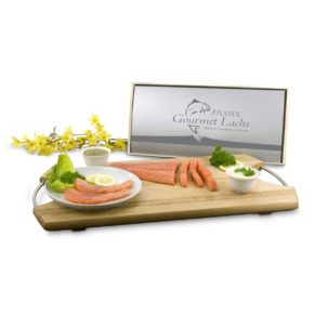 Dieses zartgeräucherte Rückenfilet-Stück Gourmet Lachs ist ein ganz besonderes Highlight. 600-800 g feinstes, rauchzartes Filet, handfiletiert, mit je 50 g Sahne-Meerrettich und Senf-Dill Sauce, arrangiert in einer Holzkiste, Maße: ca. L49 x B24 x H5,5 cm. Zutaten: Sahne-Meerrettich: Meerrettich, gerieben, Rapsöl, SAHNE 25%, Branntweinessig, Zucker, MOLKENERZEUGNIS, Verdickungsmittel, GUARKENMEHL und Xanthan, Jodsalz, Säuerungsmittel Citronensäre, Antioxidationsmittel Ascorbinsäure und Natriummetabisulfit., Senf-Dill. Nährwertangaben: Sahne-Meerrettich: Brennwert 1336 kJ (319 kcal); Fett 26,2g, daon gesättigte Fettsäuren 3,5g; Kohlenhydrate 14,8g, davon Zucker 14,3g; Eiweiß 3g; Salz 0,8g, Schottischer Räucherlachs: Brennwert 731 kJ (175 kcal); Fett 8,5g, davon gesättigte Fettsäuren 2g; Kohlenhydrate 0g, davon Zucker 0g; Eiweiß 24,5g; Salz 0g, Senf-Dill-Sauce: Brennwert 1115 kJ (266 kcal); Fett 9,8g, davon gesättigte Fettsäuren 0,7g; Kohlenhydrate 39,1g, davon Zucker 37,9g; Eiweiß 2,5g; Salz 2g. Allergiehinweis: Sahne-Meerrettich: Enthält Milch, Lactose, Schwefeldioxid und Sulfite. Senf-Dill Sauce: Enthält Senf.<br>