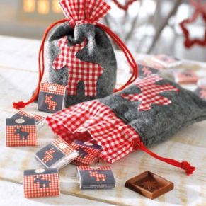 Das Set besteht aus einem Weihnachtsbeutel Elch aus weichem Filz, mit Zugband und weihnachtlichen Verzierungen und 60 leckeren Edelvollmilch-Schokoladen-Quadraten, je á ca. 5g, mit einem passenden Elch-Wickler. Bedruckt mit niedlichen grauen und rot-